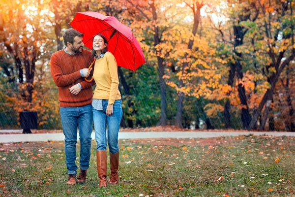 Genç çift erkek ve kadın bir şemsiye altında yürümek — Stok fotoğraf