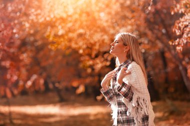 Isınan sonbahar güneşinin tadını çıkaran kadın