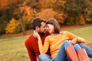 Güzel genç çift yüz yüze oturuyor ve gülümsüyor.