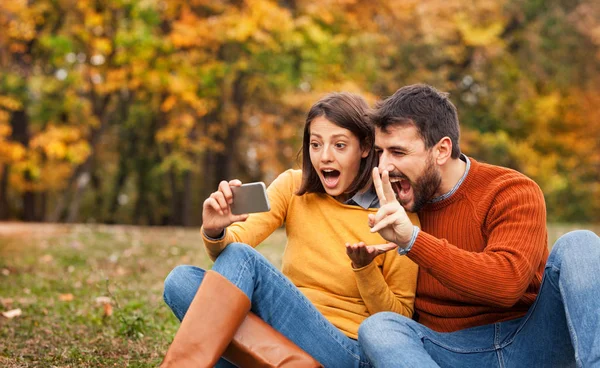 Jovem casal vídeo conversando com seus amigos no parque da cidade — Fotografia de Stock