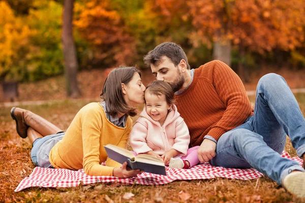 Mutlu genç aile piknik battaniye üzerinde eğleniyor 