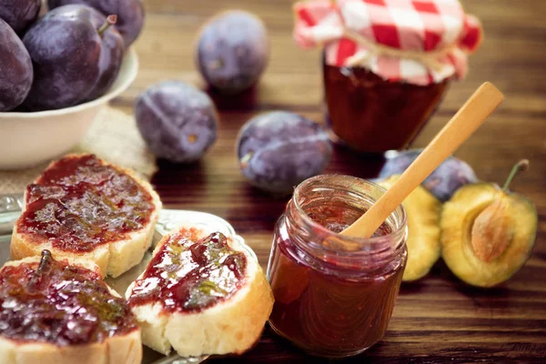 Prunes sucrées sur fond en bois avec confiture de prunes — Photo