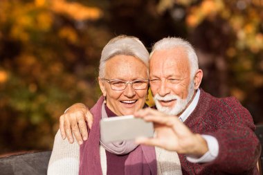 Modern büyükanne ve büyükbaba selfie çekerken çift 