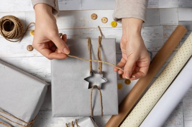 Bir kadının eli hediye tutarken ya da hediye kutusunu pastayla süslerken. 