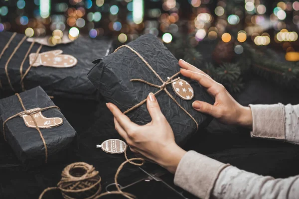 Frau dekoriert Geschenke mit selbstgebasteltem Weihnachtsschmuck — Stockfoto