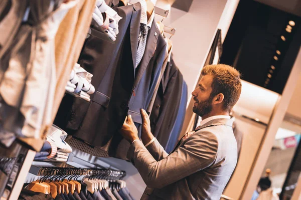 Мужчина выбирает одежду в магазине — стоковое фото