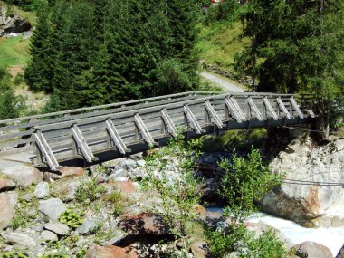 Maderanertal Alpine vadisindeki Charstelenbach akarsu üzerinde ahşap yollar ve köprüler-Uri Kantonu, Isviçre