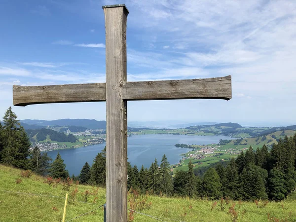 A wooden crucifix and a chapels on the slopes around the artificial Lake Sihlsee, Einsiedeln - Canton of Schwyz, Switzerland