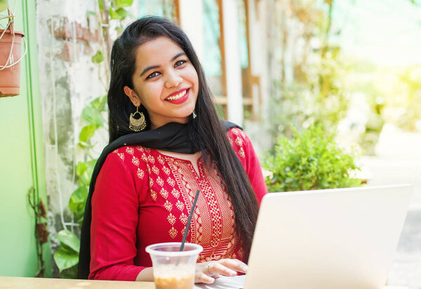 Pretty young indian woman in traditional clothes with laptop