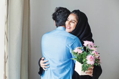 Mutlu Müslüman kadın akrabasından hediye olarak çiçek alıyor.