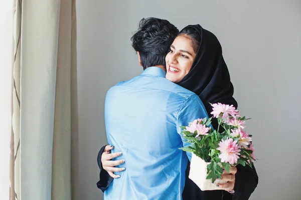 Glückliche muslimische Frau bekommt Blumen als Geschenk von ihrem Verwandten — Stockfoto