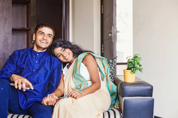 Feliz pareja india casada sentada en un sofá en su propia casa. — Foto de Stock