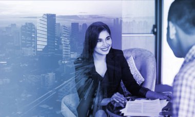 İş geçmişi: Asyalı profesyonel kadın müşteriye imza için belge veriyor, Jakarta şehir görüşüyle örtüşüyor