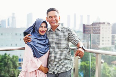 Mutlu Endonezyalı çift Jakarta City V 'in balkonunda kucaklaşıyor.