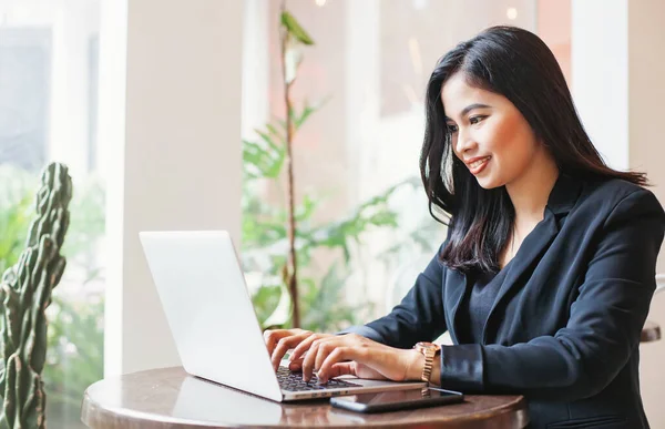 Jóvenes empresarios asiáticos que trabajan en un ordenador portátil en un café — Foto de Stock