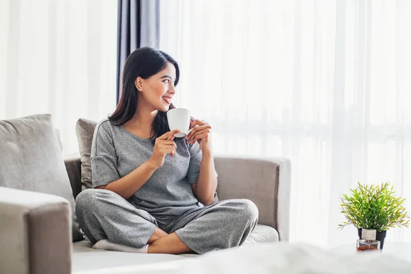 Jonge Aziatische Vrouw Drinken Koffie Een Slaapbank Thuis — Stockfoto