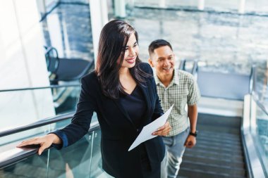 Endonezyalı işadamları Jakarta 'daki ofis binasında yürüyen merdivenden çıkıyorlar.