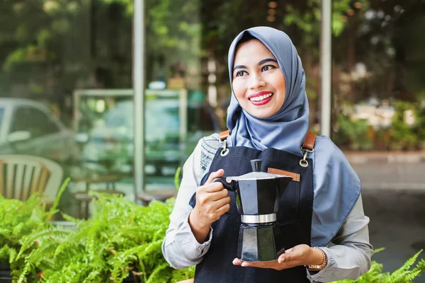 レストラン カフェ コーヒーショップでホットコーヒーを持参かわいいインドネシアのイスラム教徒のウエイトレス屋外 — ストック写真