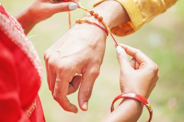 El fotoğrafı: Hintli bir kadın kardeşinin eline rakhi bağlıyor.
