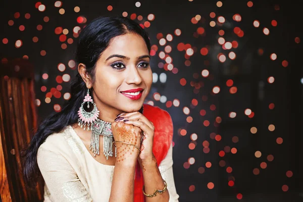 若い美しいインドの女性は 宝石やお祝いの民族衣装を着て座って ボケの背景を待っています — ストック写真
