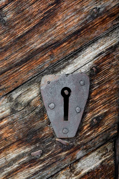 Ancient door locker in an old, carved wood door