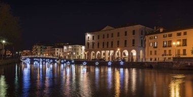 4 Ocak 2019 Treviso (Kuzey İtalya): Treviso gece Noel zamanı sırasında. Üniversite Köprüsü ve ışık yıldız Sile Nehri üzerinde yansıtır. Üniversite binası sağda.