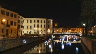 4 Ocak 2019 Treviso (Kuzey İtalya): Treviso gece Noel zamanı sırasında. Üniversite Köprüsü ve ışık yıldız Sile Nehri üzerinde yansıtır. Üniversite bina sol.
