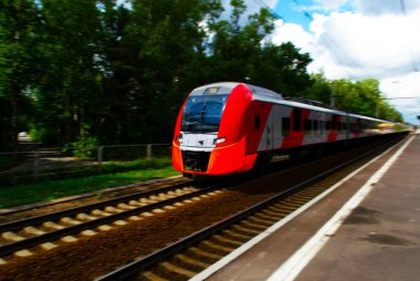 oldukça parlak bir ışıkta istasyonda tren