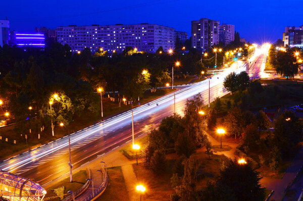 движение в городе ночью в довольно ярком свете
