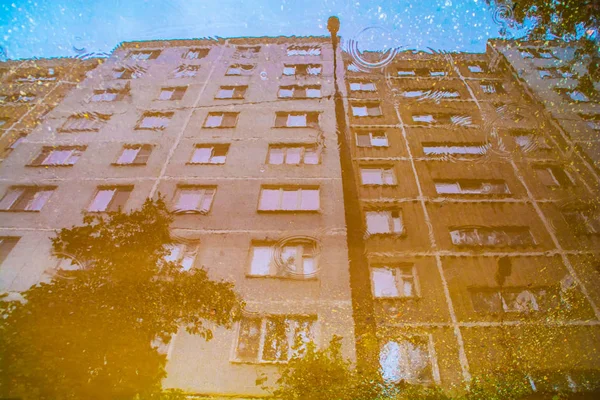 Das Gebäude Spiegelt Sich Einer Pfütze Auf Dem Bürgersteig — Stockfoto