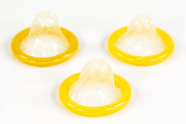 Beyaz arka plan üzerinde izole 3 kısmen aktarılmış prezervatif