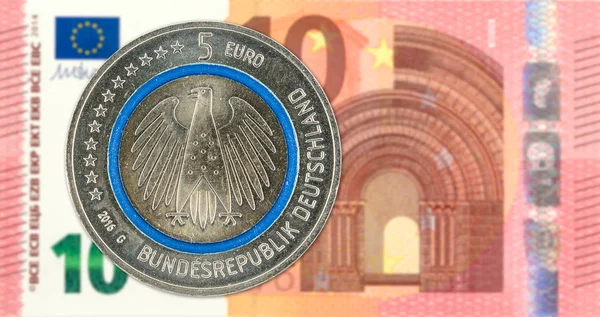 5 euro coins against 10 euro bank note obverse