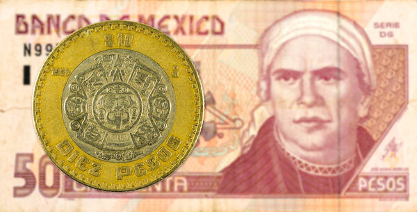 10 mexigan peso coin against 50 mexican peso bank note