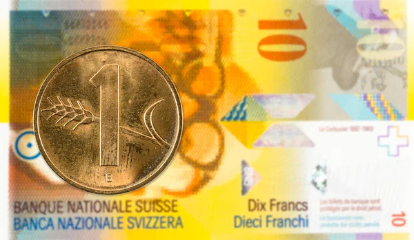 1 swiss rappen coin against 10 swiss franc bank note
