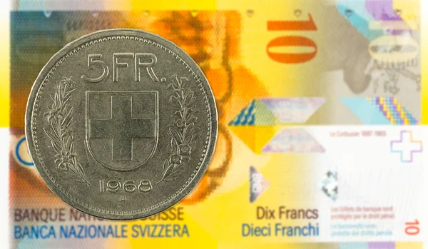 5 swiss franc coin against 10 swiss franc bank note