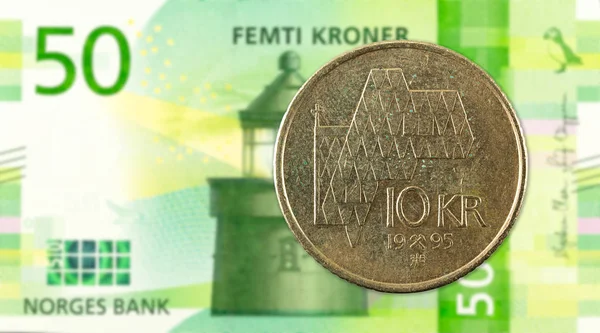 10 norwegian krone coin against 50 new norwegian krone banknote