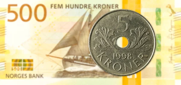 5 norwegian krone coin against 500 new norwegian krone banknote
