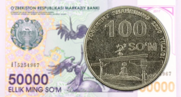 100 uzbekiska som mynt mot 50000 uzbekiska som sedel — Stockfoto