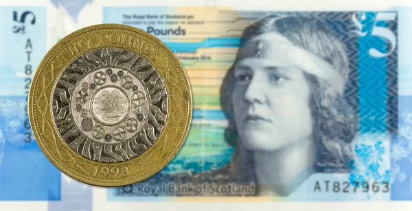 2 Pounds coin against 5 Pounds Sterling note issued by Royal Ban