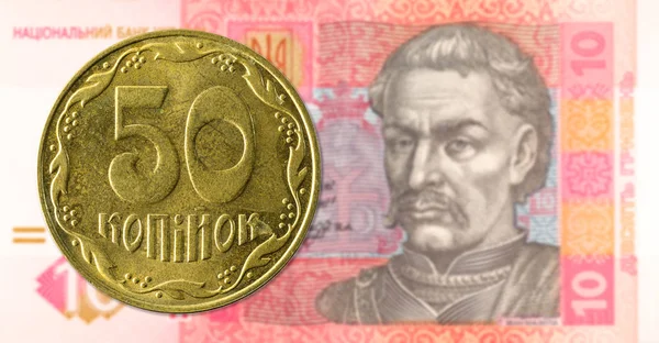 50 ukrainska Kopiyka Coin mot 10 ukrainska hryvnia sedel — Stockfoto