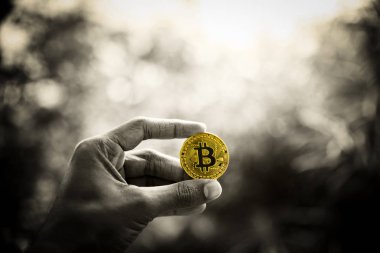 Yeni bir sanal para dijital sembolü bir adam elinde altın Bitcoin.