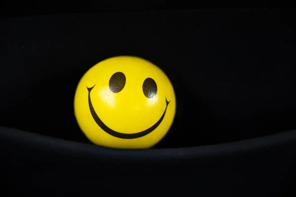 Yellow stress ball in a black background