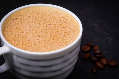 Siyah arka planda bir fincan sıcak kahve.