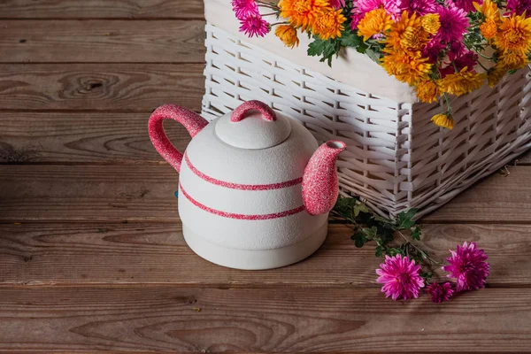 Kettle and white basket with chrysanthemums — Stock Photo, Image