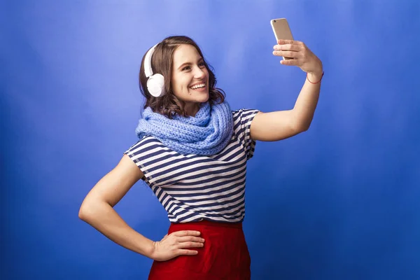 Cheerful girl with headphones and a telephone — Stock Photo, Image