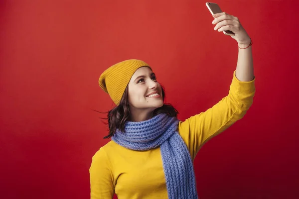 Smiling girl with a phone makes selfie — Stock Photo, Image