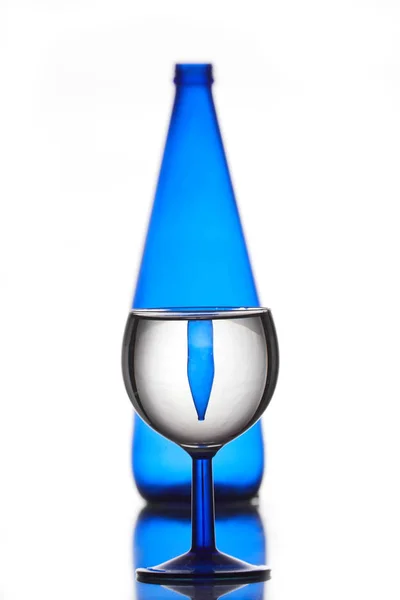 Uma garrafa azul e um copo — Fotografia de Stock