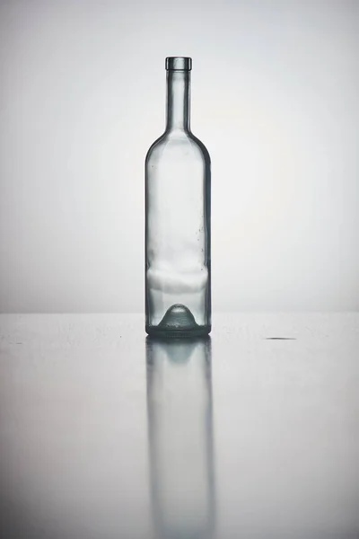 Lege fles op grijze achtergrond — Stockfoto
