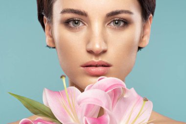 kısa bir saç kesimi ve pembe bir zambak ile güzel esmer 