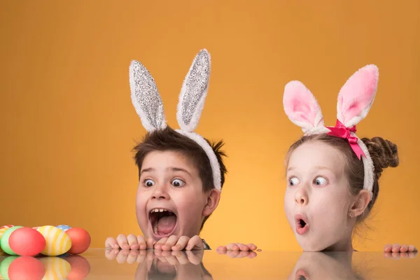 Crianças surpresas olhar para ovos de Páscoa — Fotografia de Stock